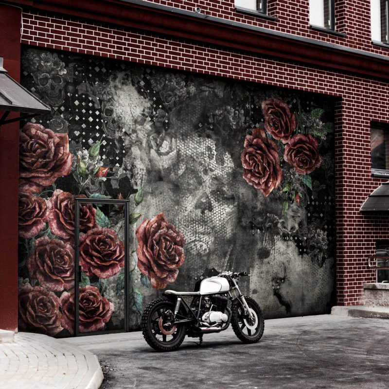 Moto grise reconstruite, moto caferacer devant les portes roulantes d'un garage