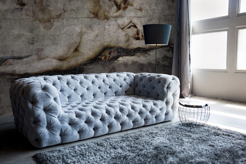 Gray sofa against the background of a worn wall and window